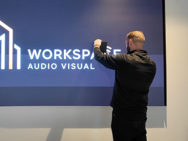 man standing in front of a sign that reads workspace audio visual
